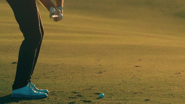 Golfer hitting approach shot with iron in extreme slow motion from behind, exploding divot on par 3 at 4k 800fps at golden hour at twilight on Texas golf course tilt up