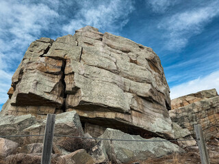 The iconic Big Rock, a massive glacial erratic in Okotoks, Alberta, stands tall under a vibrant...