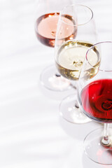 Three wine glasses filled with red, white, and rose wine