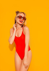 Young smiling blond model in summer swimwear colourful bathing suit. Sexy carefree woman having fun...