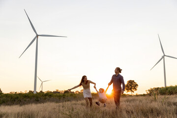 Family with son walking on field on wind farm. Happy Family and son playing at the Wind turbines...