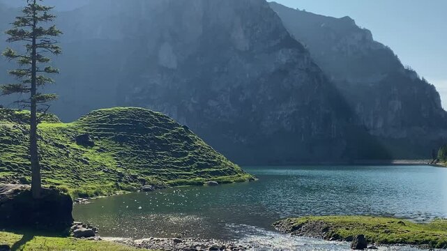 Pristine alpine valley and crystal clear Bannalp lake, Switzerland on sunny summer day