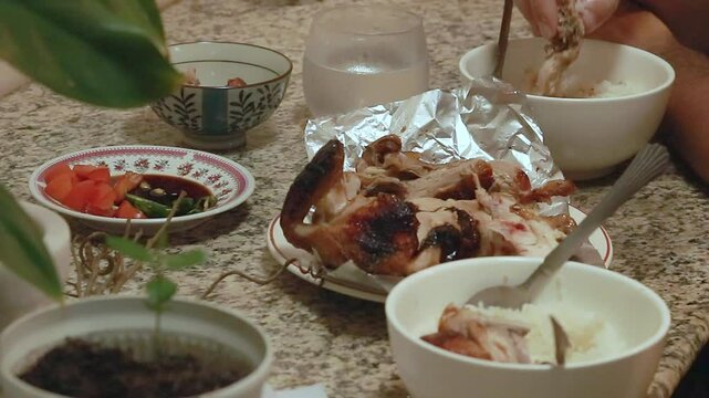 Eating lechon manok with rice paired with soysauce condiment or sawsawan, authentic local Filipino meal