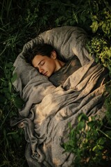 Obraz premium Person sleeping soundly, wrapped in fabric, amidst greenery.