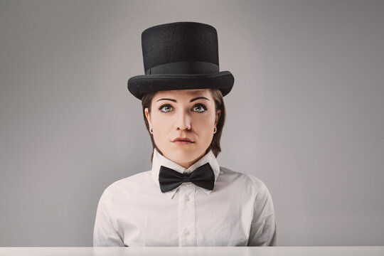 Young woman wearing top hat and bow tie posing for a portrait