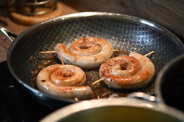 cooking sausages on a frying pan, close-up