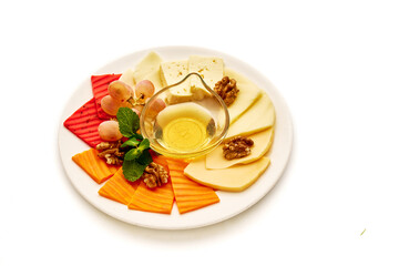 A plate of food with a variety of fruits and cheese, including walnuts