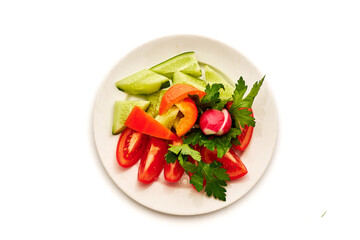 A plate of vegetables including tomatoes, cucumbers, and radishes