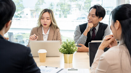 Executives are having a meeting with employees to discuss business planning in a conference room.