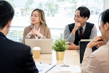Executives are having a meeting with employees to discuss business planning in a conference room.