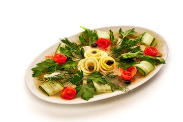 A white plate with a variety of vegetables including cucumbers, tomatoes