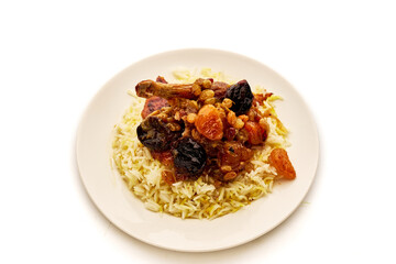 A plate of rice and meat with fruit on top
