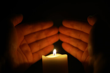 Gently Cupped Hands Encircling Glowing Candle Flame in Dark, Warm Light and Peace Concept