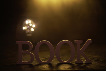 Illuminated Wooden Book Letters Against Dark Background with Warm Light Bokeh Effect