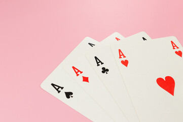 Top view of playing cards on pink background. Four aces cards, board game, poker. Copy space, flat lay.