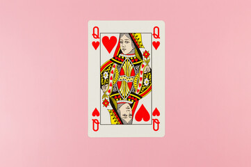 Top view of playing cards on pink background. One queen card, board game, poker. Copy space, flat lay.