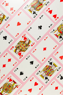 Top view of playing cards on pink background. Lot of cards, board game, poker. Copy space, flat lay.