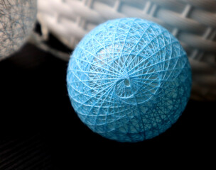 A ball of blue threads intersecting to form a pattern. Christmas decoration. Garland. On a black and white background. Macro photo.