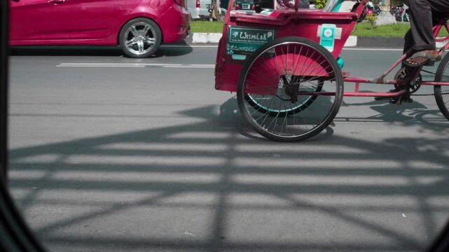 City streets of Makassar featuring a blend of becak (rickshaws), cars, and motorcycles