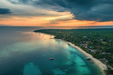 Fototapeta premium Dramatic sunset over tropical island coastline, boats, beach, and turquoise water.