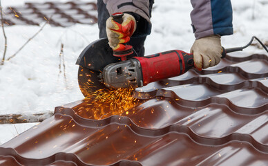 A man is using a power tool to cut a piece of metal