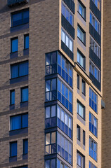 Cityscape on a summer day, modern buildings and houses against the blue sky 