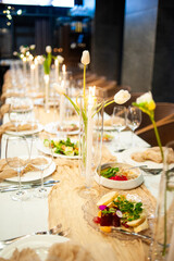 beautiful table setting with flowers and cutlery on wooden table at wedding or dinner. stylish tablewear decorations	