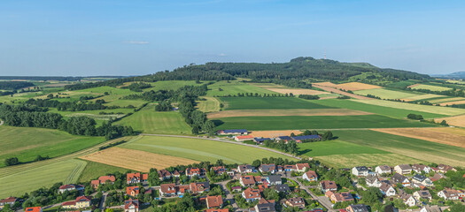 Obraz premium Ausblick auf Wittelshofen am Hesselberg in Mittelfranken an einem sonnigen Sommerabend