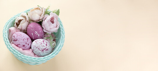 Easter eggs, feathers in a nest on a yellow background. The minimal concept. Top view. Card with a copy of the place for the text