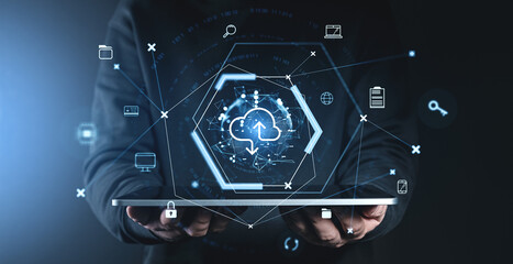 Cloud computing concept with data icons and cloud symbol on futuristic interface held by person on dark blue background.