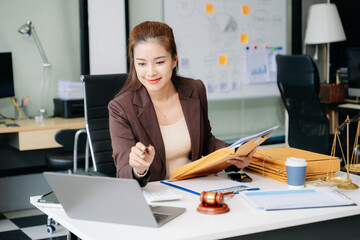 Confident lawyer working on legal analysis at a modern office desk, featuring scales of justice, a gavel