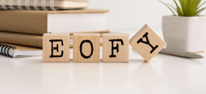 EOFY, End of Financial Year text. wood cubes and white background