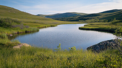 Obraz premium Serene lake surrounded by lush green hills on a clear sunny day