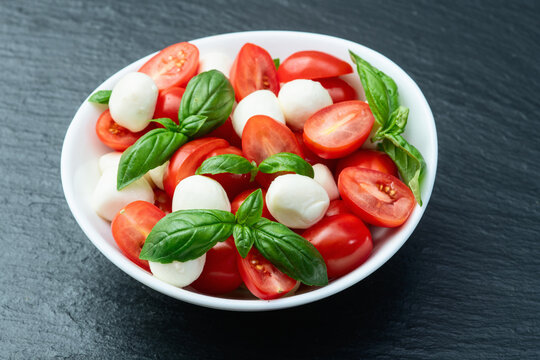 Basil leaves , cherry tomatoes and mozzarella cheese . In bowl food photography - Powered by Adobe