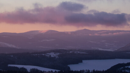 Colorful sunset over the Czech countryside. View of the Krkonoše mountains from the Teplice-Adršpašská rocks.