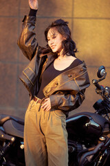 Oriental beauty taking photos on a retro motorcycle at sunset