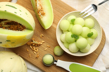 Melon balls in bowl and fresh fruit on table, top view