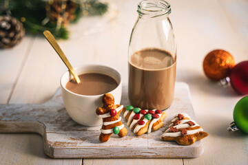 Heißer Kakao in einer Tasse und einer Glasflasche auf einem weißen Holz Tisch. Lebkuchen Keks, Weihnachten.