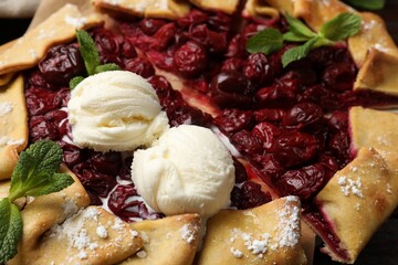Tasty galette with cherries and ice cream on table, closeup