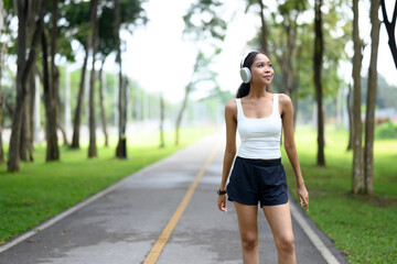 African American woman listening to music through headphones, enjoying a peaceful walk in the park