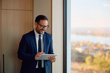 Fototapeta premium Happy businessman using touchpad while working in office.