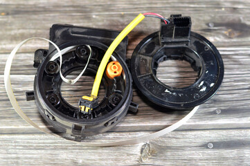 Broken airbag spiral cable clock spring for automobiles, that stores energy on a rotating axis, consist of a flat multicore cable wound in a spiral shape, spiral-wound rotary electrical conductor