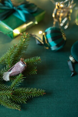 Christmas decorations festive frame with branch of fir on the green linen cloth. Close up. Copy space