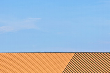 The front view shows only the roof of the building with a blue sky.