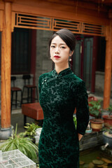 Asian woman wearing retro cheongsam in a Chinese courtyard