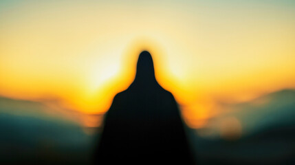 Blurred silhouette of Jesus in a tranquil landscape at sunset radiating peace and divinity