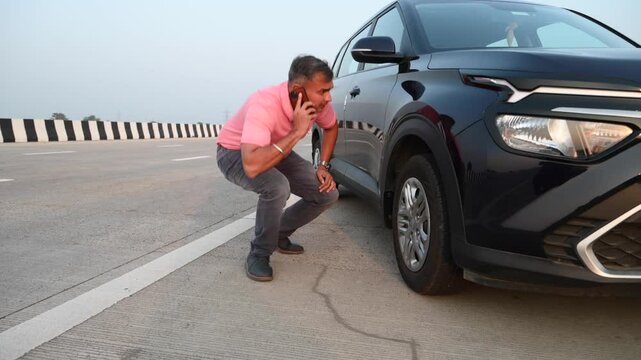 Stressed Indian man anxious driver talk mobile phone in city breakdown car with open bonnet background road accident broken auto automobile