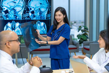 Group of professional doctors engaged in a discussion or meeting in a medical office. A large monitor displaying multiple MRI brain scans, to revolve around patient diagnosis and treatment planning.