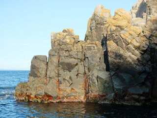 Kullaberg, rock formations - The vibrant rock formations of Kullaberg, Sweden, reveal nature's forces and a history of smuggling, impressively viewed from the water.