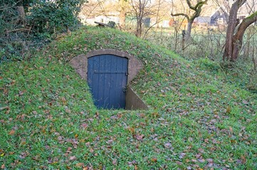 Grassy hill with an entrance door to a cellar to store potatoes.